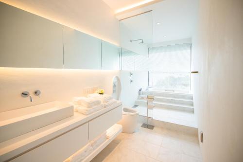 a white bathroom with a sink and a toilet at Wellis Villa HANARE in Awaji