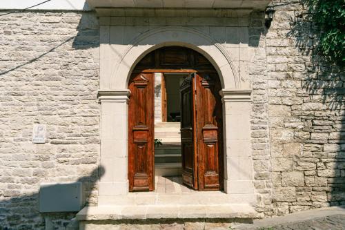 an entrance to a building with wooden doors at Petrichor in Gjirokastër