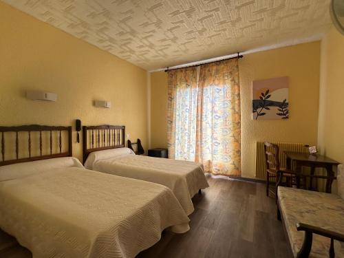 une chambre d'hôtel avec deux lits et une fenêtre dans l'établissement Hôtel AMBEILLE COLLIOURE, à Collioure