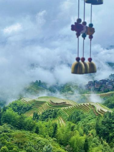 a group of clocks flying over a hill with clouds at Longji Panorama Hotel 龙脊全景楼大酒店 in Longsheng