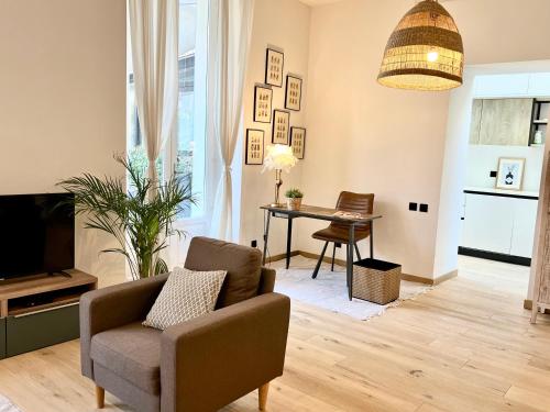 a living room with a chair and a table at Sweett - Hotel Particulier Garden in Cannes