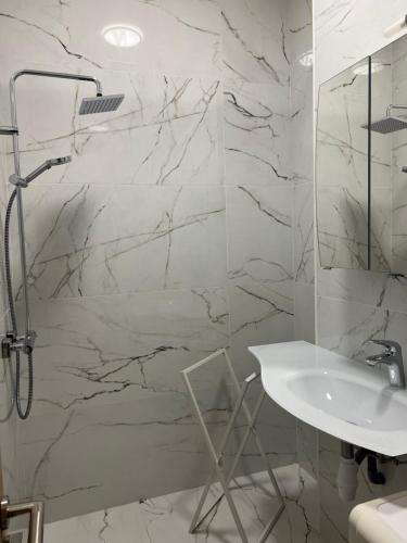 une salle de bain blanche avec un lavabo et une douche dans l'établissement Long stay nearby Mariottes H Nice town, à Nice