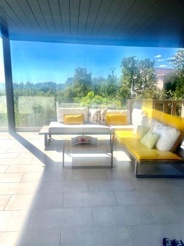 un patio avec deux canapés, une table et un pare-soleil dans l'établissement Villa Floralies, à Vidauban