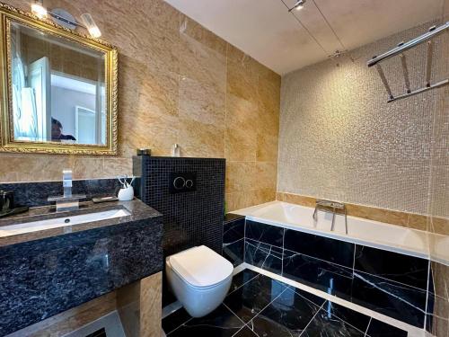 une salle de bain avec une baignoire, des toilettes et un lavabo dans l'établissement Spacieuse Villa avec piscine, à Mougins