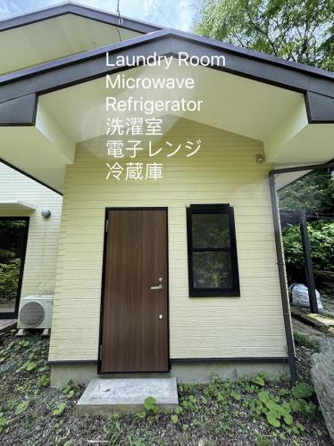 a sign on the side of a building with a door at 箱根仙石原心温まる雅宿 in Hakone