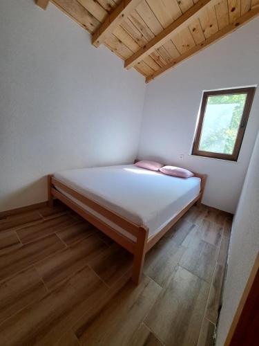 a bedroom with a bed in a room with a window at Guest house SARA in Čapljina
