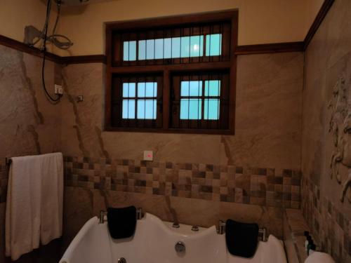 a bathroom with two sinks and a tub and a window at Heaven Palace in Kandy