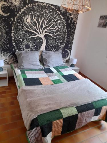 a bedroom with a bed with a tree on the wall at Kalystoun in Valdeblore