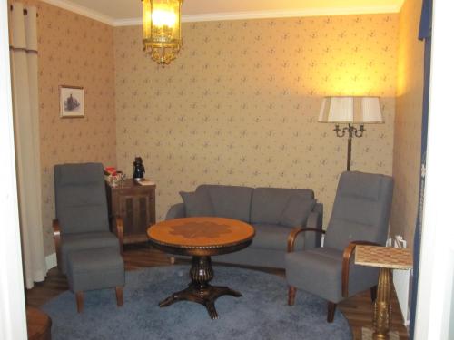 a living room with chairs and a table and a table and a tablektop at Hotelli-Ravintola Alma in Seinäjoki