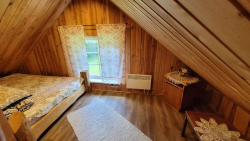 an attic room with a bed and a window at Tabani Puhketalu SAUNAMAJA in Tamna