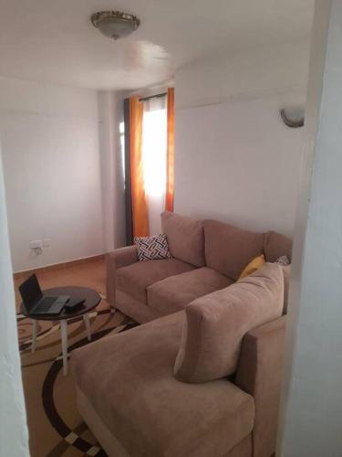 a living room with a couch and a table at Nyona Homes in Kalimoni