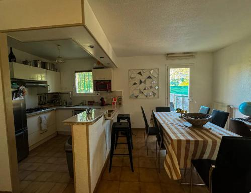 une cuisine et une salle à manger avec une table et une nappe dans l'établissement Villa tout confort, à Fréjus