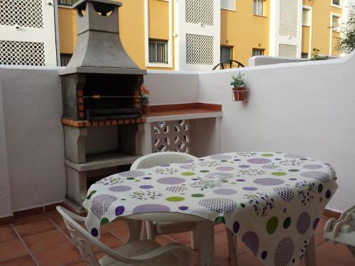 a table and chairs on a balcony with a stove at Bonito apartamento con barbacoa in Benalmádena