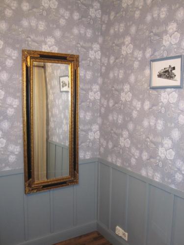 a mirror on a wall with floral wallpaper at Hotelli-Ravintola Alma in Seinäjoki