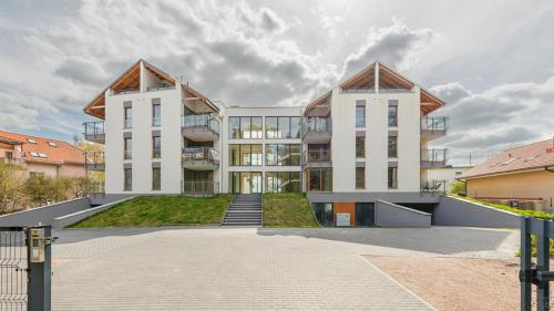 a large apartment building with two large white buildings at Apartament Diuna in Krynica Morska