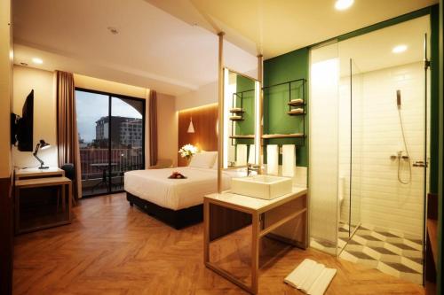 a bedroom with a bed and a shower and a sink at Patra Malioboro Hotel in Yogyakarta