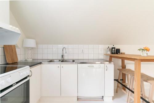 a kitchen with white cabinets and a sink at Falsterbo - Sea Breeze Apartment in Malmö