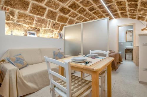 ein Wohnzimmer mit einem Tisch und einem Sofa in der Unterkunft Deliloft in Alghero