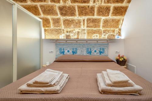 ein Schlafzimmer mit einem großen Bett, auf dem Handtücher liegen in der Unterkunft Deliloft in Alghero