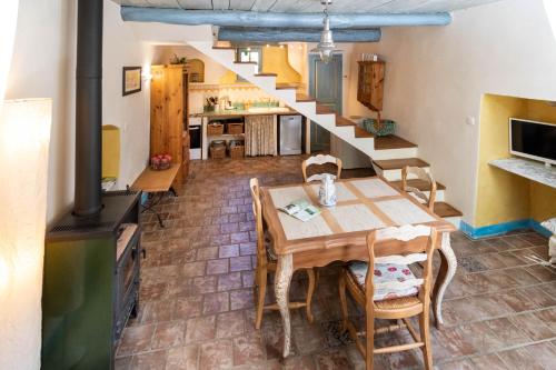 une cuisine et une salle à manger avec une table et un escalier dans l'établissement Domaine de la Clédette grand gîte, à Colognac