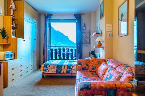 a living room with a couch and a large window at Happy Guest Apartments - Pink Mountain Presolana in Castione della Presolana