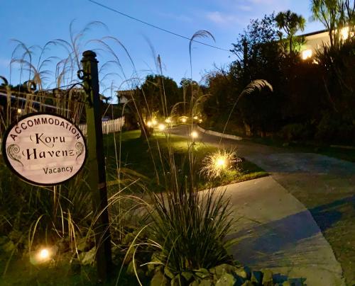 a sign on a sidewalk next to a street with lights at Koru Havenz in Picton
