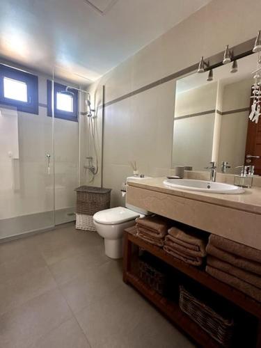a bathroom with a toilet and a sink and a mirror at Residencial Noray Duplex 26 in Puerto Calero
