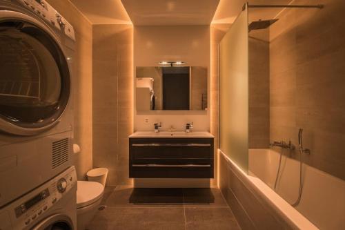 a bathroom with a sink and a toilet and a washing machine at Independance First in Interlaken