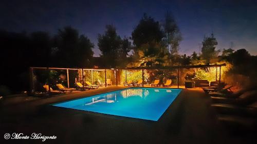 a swimming pool at night with chairs around it at Monte Horizonte - Turismo Rural- Casas de Campo - Eco e Natureza - Adults Only in Santiago do Cacém