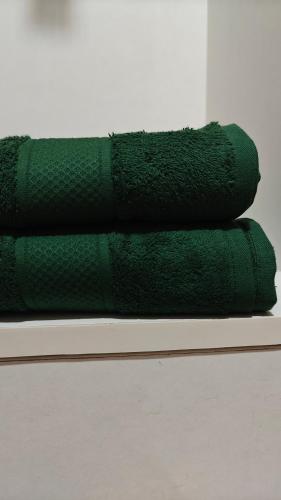 a stack of green towels sitting on a shelf at 116 Home Tales by Tipiverse, BTM Layout - NO CAR PARKING in Bengaluru