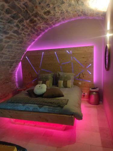 - une chambre avec un lit à éclairage violet dans l'établissement lesoleilo, à Mostuéjouls