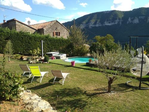 une cour avec des chaises et une piscine dans l'établissement lesoleilo, à Mostuéjouls