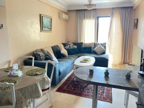 a living room with a blue couch and a table at Luxury apartment 3 in the heart of Gueliz, Wifi, Pool in Marrakech