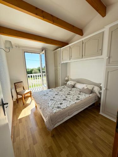 une chambre avec un grand lit et un balcon dans l'établissement Les aigrettes, à Saint-Pierre-dʼOléron