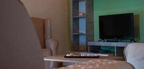 a living room with a table and a tv at Monte Horizonte - Turismo Rural- Casas de Campo - Eco e Natureza - Adults Only in Santiago do Cacém