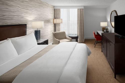 a hotel room with a large bed and a desk at The Westin Dallas Fort Worth Airport in Irving