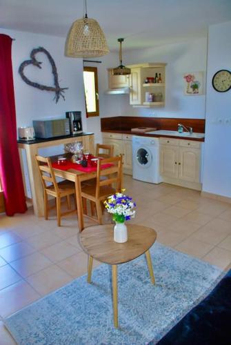 une cuisine et une salle à manger avec une table et une table et des chaises dans l'établissement Les Marmottons De LAYE, à Laye