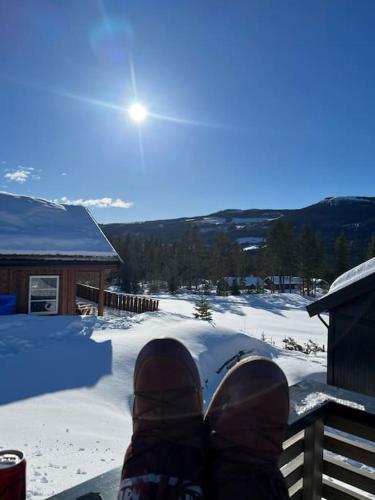 a person sitting on a porch in the snow at Modern cabin, great view, sunny, 2BA, 4BR in Hemsedal