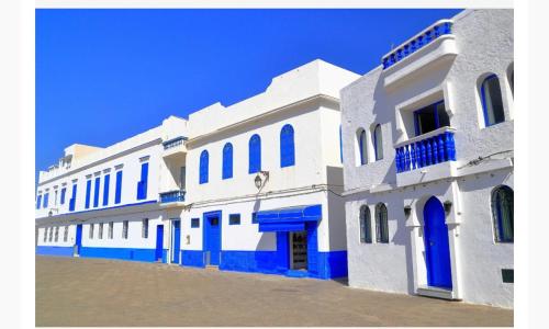 a white and blue building with blue doors and windows at Jardins de ASSILAH in Asilah