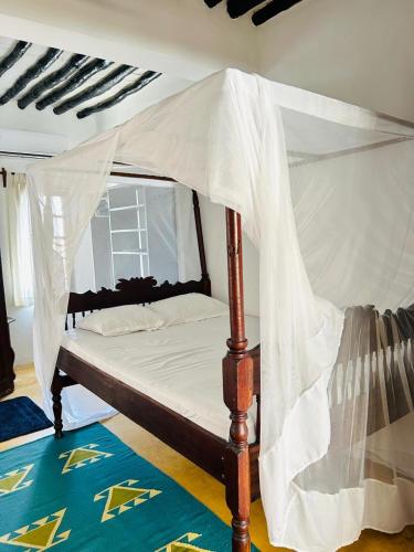 a bed with a canopy in a room at Shela Bahari in Shela