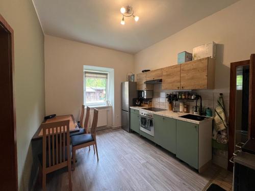 a small kitchen with a table and a refrigerator at Ausseerland Apartments - Relax, Ski, Hike and Bike, Garden, Parking, BBQ, Near Hallstatt, Loser, Tauplitz and Krippenstein, Free Wi-Fi and Netflix in Bad Aussee