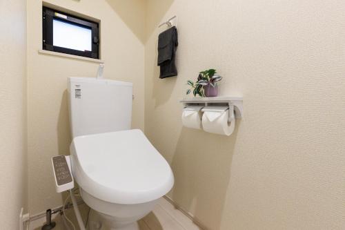 a bathroom with a white toilet and a window at オープンセール 2棟貸切 最大20名ビーチまで車で4分 駐車場4台 tla&tdy ツインズロッジA棟B棟貸切 in Yomitan