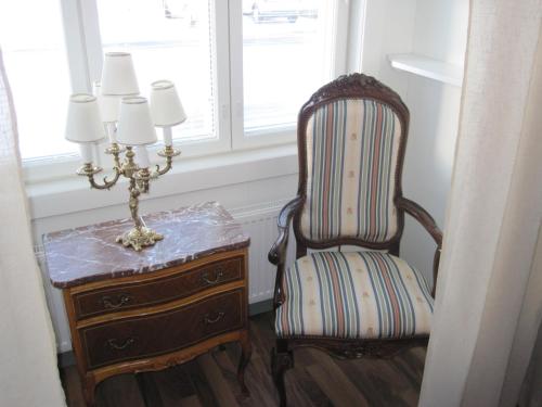a chair sitting next to a dresser and a window at Hotelli-Ravintola Alma in Seinäjoki
