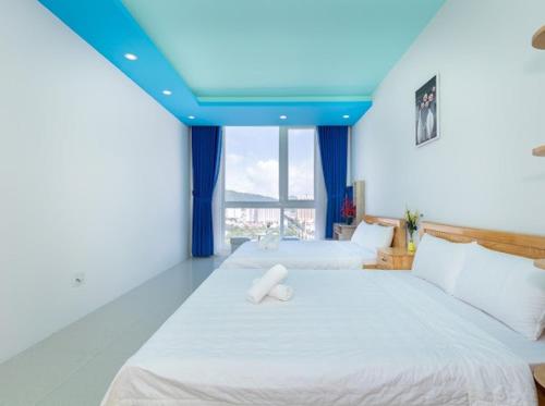 a bedroom with two beds and a blue ceiling at Khách sạn sơn thinh 23d Thuỳ Vân in Vung Tau