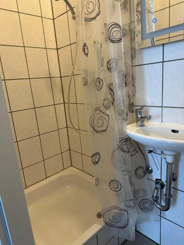 a shower curtain in a bathroom with a sink at Helles Apartment am Elberadweg in Magdeburg
