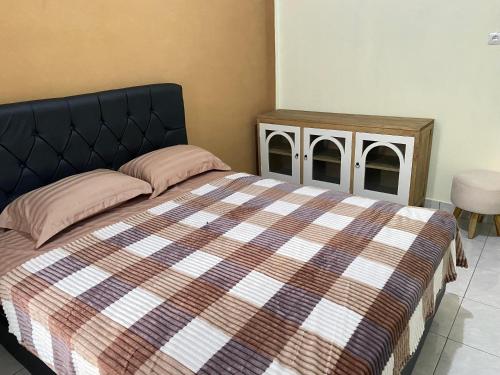 a bedroom with a large bed and a night stand at Djogja Homestay Syariah in Piyungan