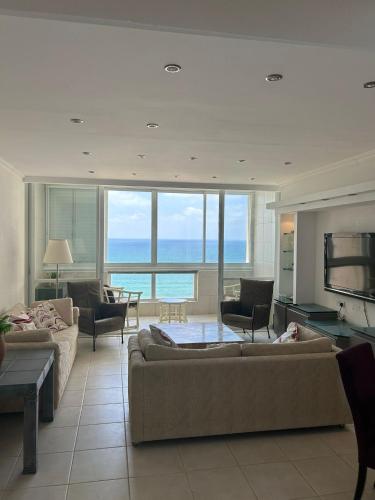 a living room with two couches and a television at Natanya Sea View in Netanya