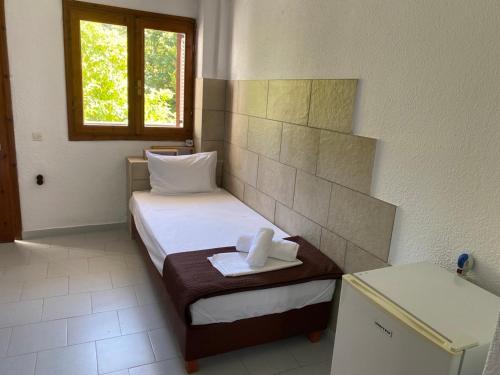 a small room with a bed and a window at Sirtaki-Siviri Apartments in Siviri