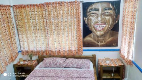 a bedroom with a large portrait of a man at Sun House Rental in Mambajao