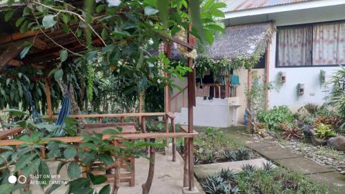 a garden with a bench in front of a building at Sun House Rental in Mambajao